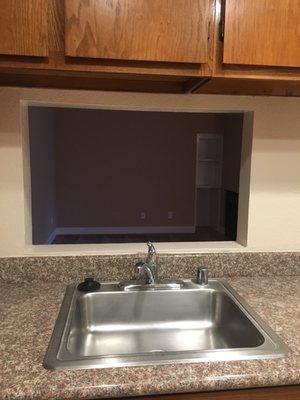 Pass through window in kitchen. Counters are some sort of rock.