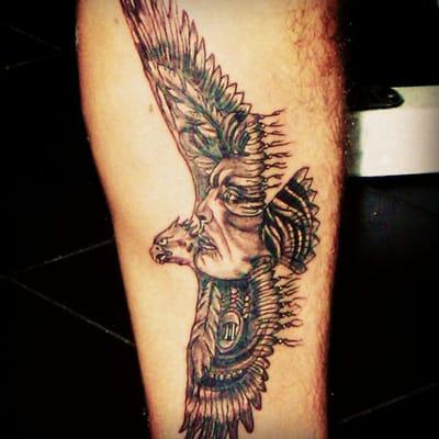 Eagle flying with an indian face inside the body and wings