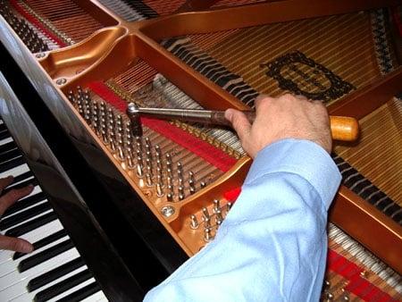 Carefully tuning pianos for decades