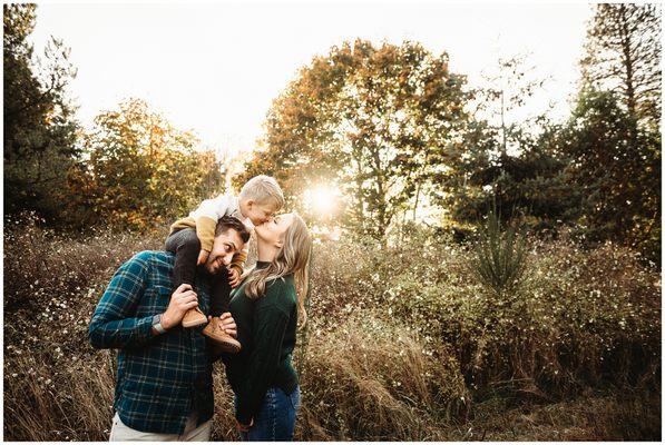 Family of three mom kissing son