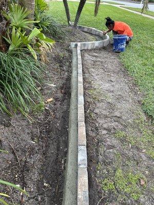 Working hard at paver trim, adding a classy border to your decorative plants.