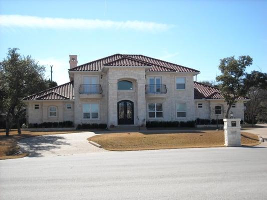 This home has a limestone exterior with a clay tile roof.