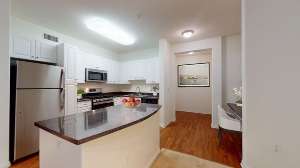 Kitchen with stainless steel appliances, island, and built-in desk.