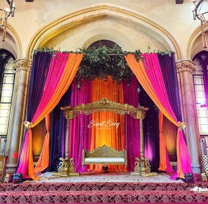 Mehndi event canopy stage decor with fresh greenery.