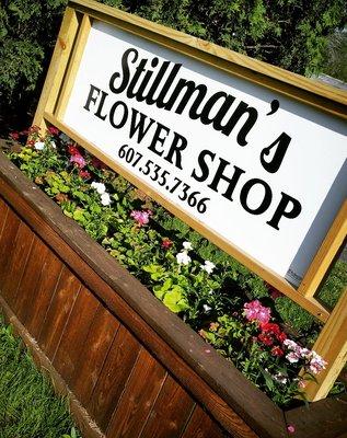 Our beautiful storefront sign with flower bed.