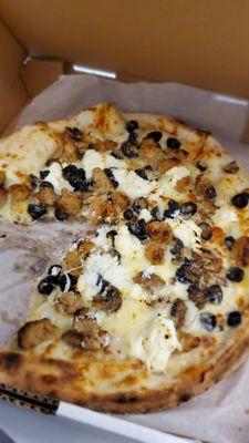 White mushroom pizza with sausage and black olives. Delish!