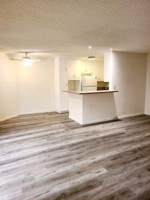 Fresh looking living room, dining room & kitchen with waterproof solid surface flooring.  All done in one day.