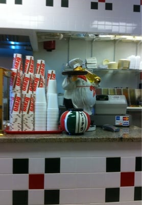 Counter, cups, register and a little statue.