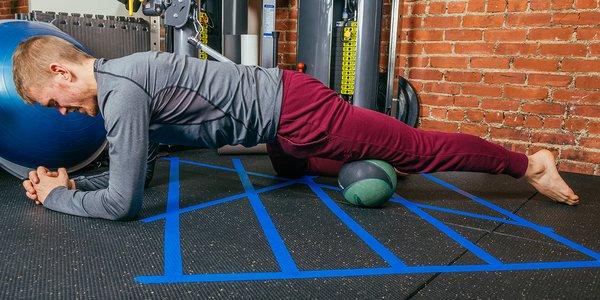 Rob showing how to roll out a knot with a medicine ball