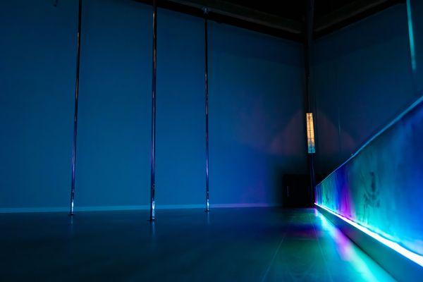 Pole studio - illuminated by white, blue, and purple lighting.