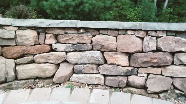 Drystack retaining wall with mortared capstone.