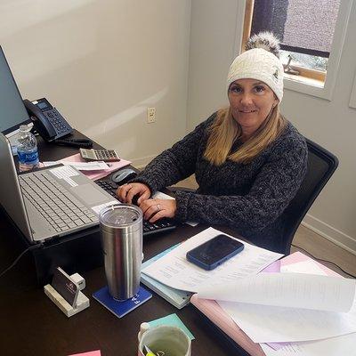 Sarah Schafer working at her desk at the Lansing office