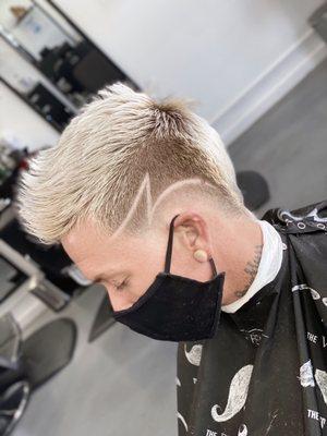 Low fade mohawk with design.