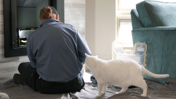 A curious cat watches our NFI-Certified gas technician troubleshoot a fireplace.