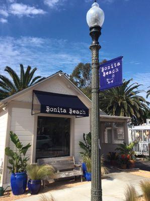 Custom sunbrella awning with logo and vinyl pole banner.