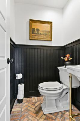 Fresh remodel of powder room. Black wainscotting and herringbone brick floor tile for the win!