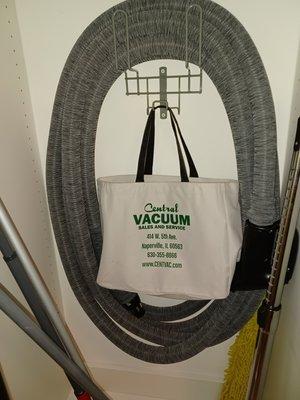 Built-in vacuum hose with sock, on hanger, with tool bag